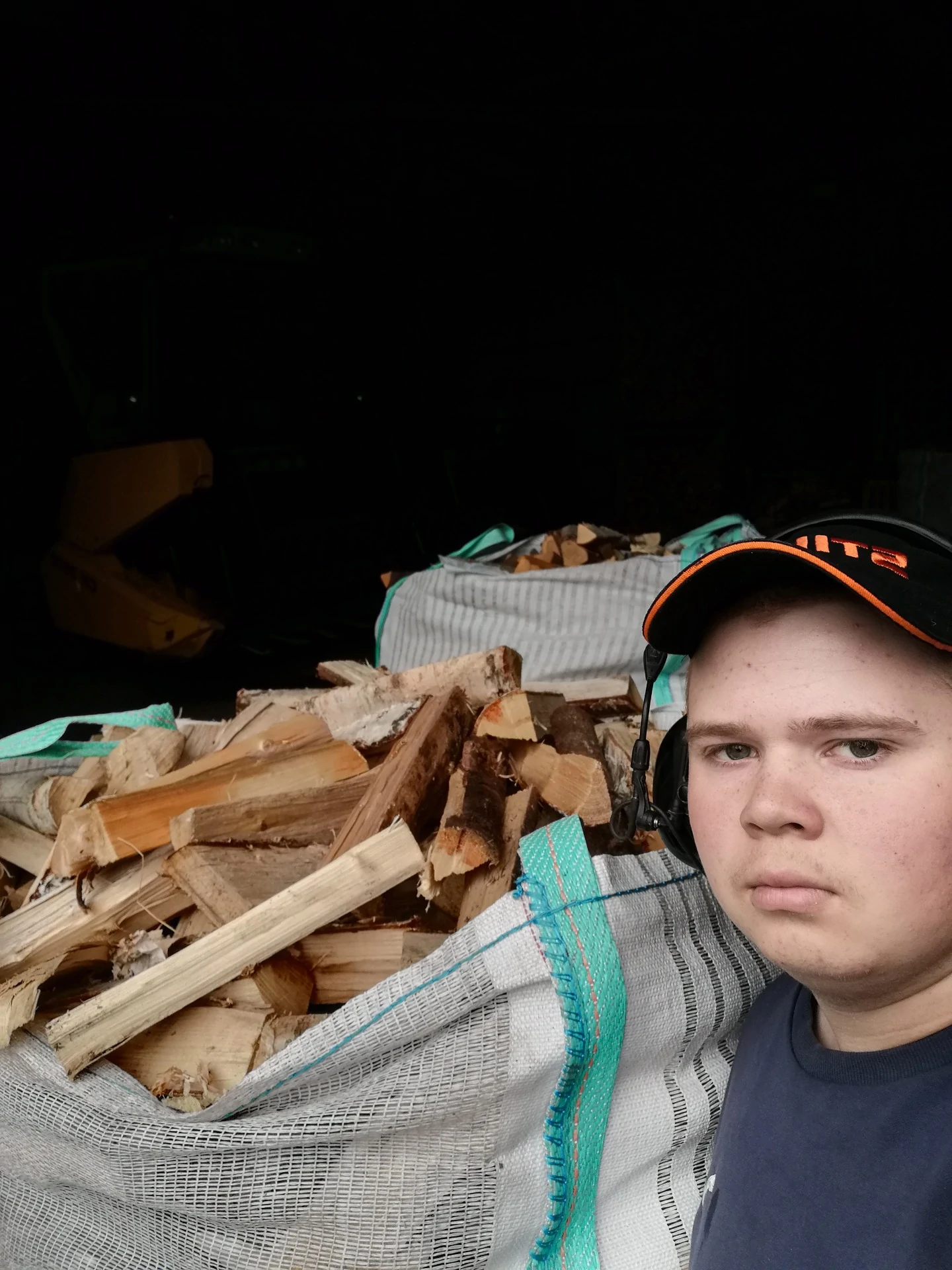 Nuori yrittäjä puukuorman vieressä valmiina toimittamaan puut asiakkaalle.